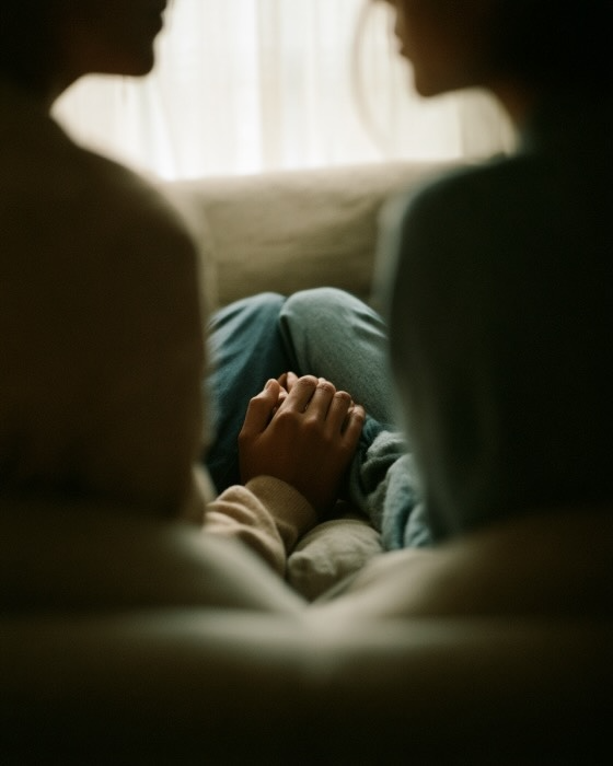 A couple sitting together, holding hands